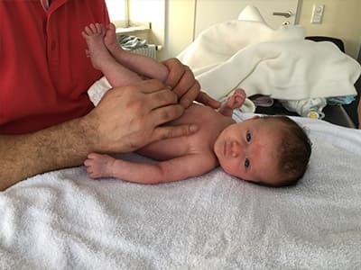 Sanfte Haltung eines Säuglings während der Behandlung in der Praxis Physiotherapie Simo.